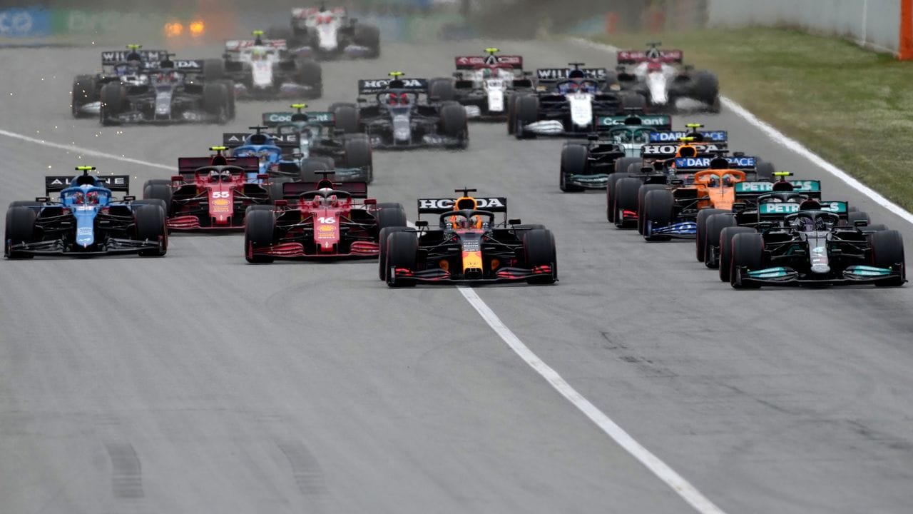 Der Niederländer Max Verstappen (M) vom Team Red Bull und der Brite Lewis Hamilton (r) vom Team Mercedes führen das Feld kurz nach dem Start an.