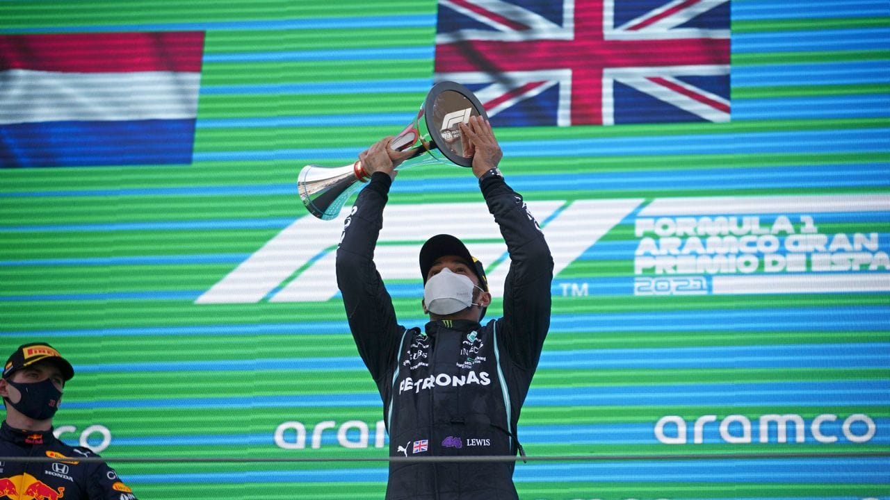 Lewis Hamilton (r) bejubelt seinen Sieg auf dem Podium.