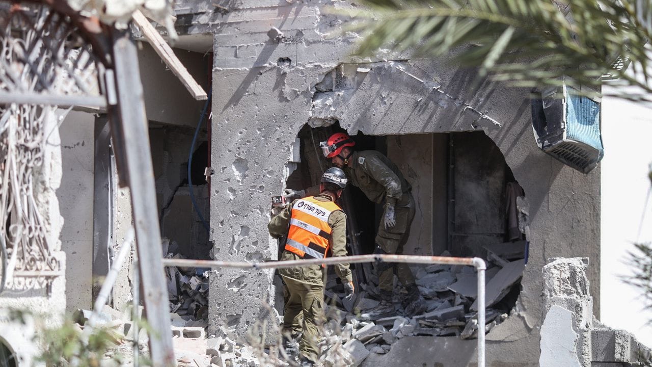 Rettungskräfte inspizieren ein beschädigtes Gebäude in Ashkelon.