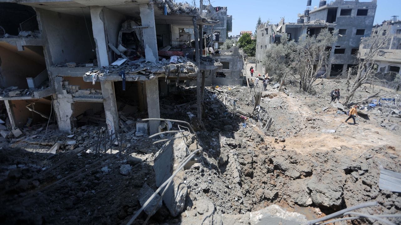 Palästinenser versammeln sich am Ort der zerstörten Häuser nach israelischen Luft- und Artillerieangriffen, während die Gewalt im Gazastreifen anhält.