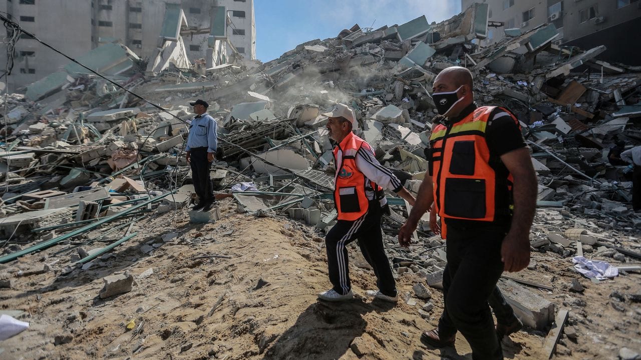 Palästinensische Sanitäter durchsuchen die Trümmer eines Gebäudes, in dem verschiedene internationale Medien untergebracht waren, darunter auch die Associated Press und Al-Dschasira, nach einem israelischen Luftangriff.