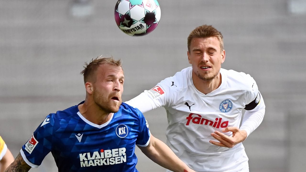 Karlsruhes Philipp Hofmann (l) im Kopfballduell mit dem Kieler Hauke Wahl. Karlsruhes Philipp Hofmann (l) im Kopfballduell mit dem Kieler Hauke Wahl.
