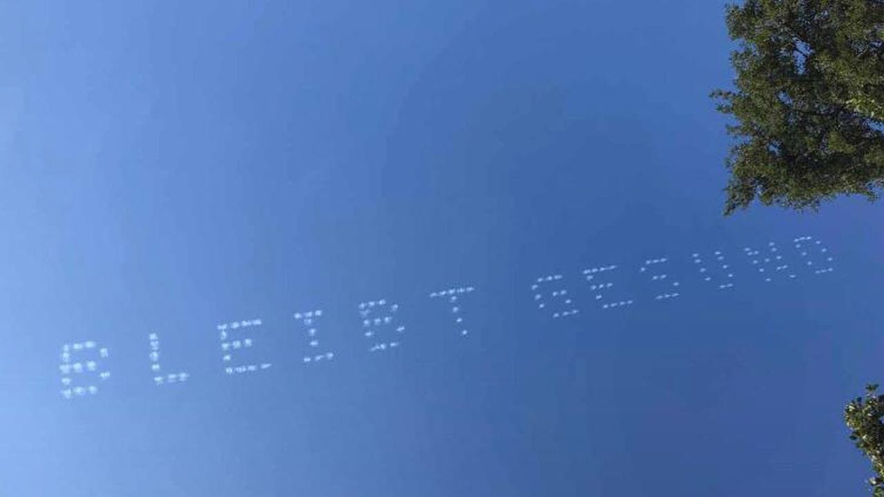 Der Schriftzug "Bleibt Gesund" am Himmel über München.