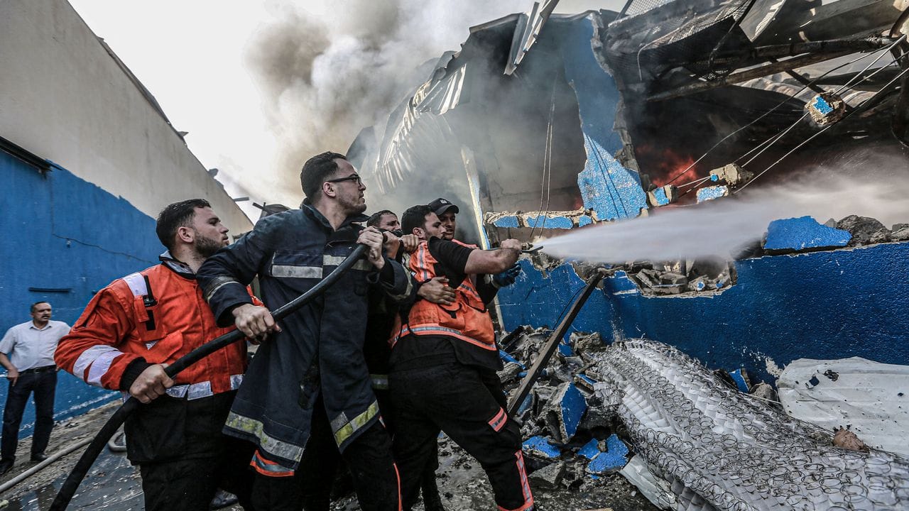 Löschversuche an einer brennenden Fabrik in Gaza.