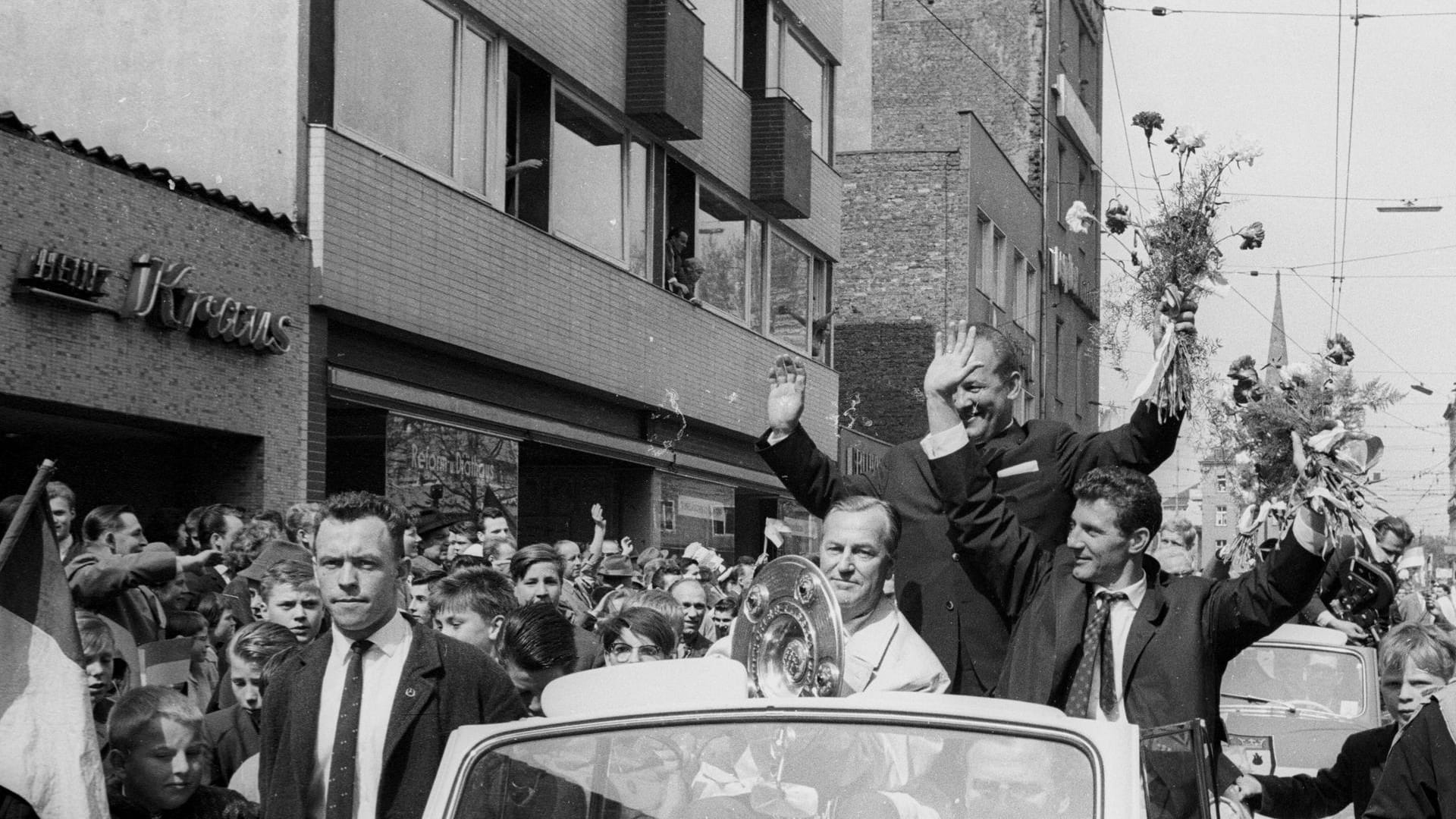 Die Fans bereiteten der Mannschaft einen triumphalen Empfang in Köln. Tausende Menschen tummelten sich auf den Straßen und jubelten ihren Helden zu. Hier lassen sich (v.r.n.l.) Präsident Kremer, Trainer Cajkowski und Kapitän Schäfer von den Anhängern feiern.