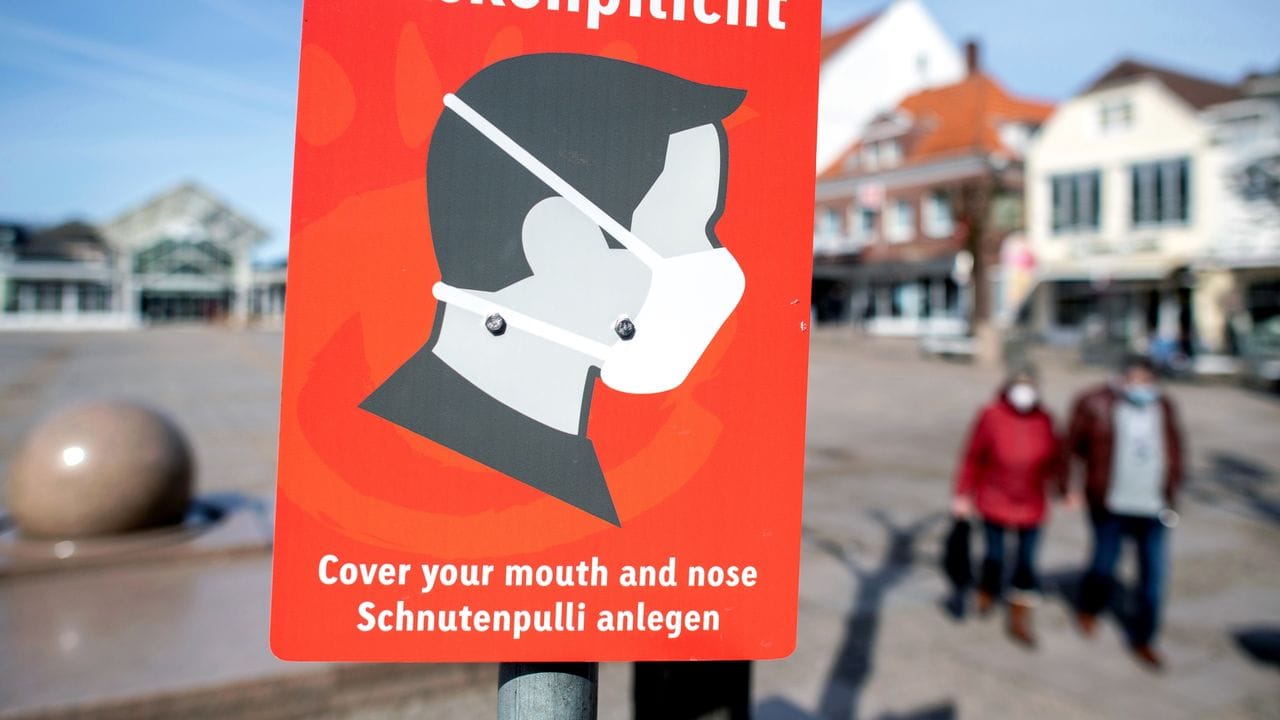Ein Schild mit der Aufschrift "Maskenpflicht" hängt auf dem Marktplatz in der Innenstadt von Aurich.