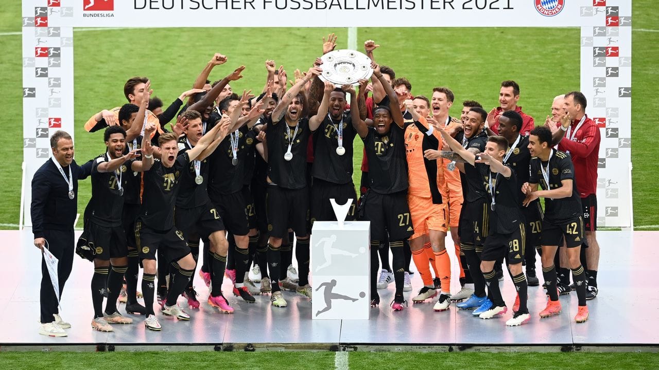Martinez (Mitte l-r), Boateng und Alaba und die Mannschaft vom FC Bayern München jubeln über den Gewinn der Deutschen Meisterschaft.