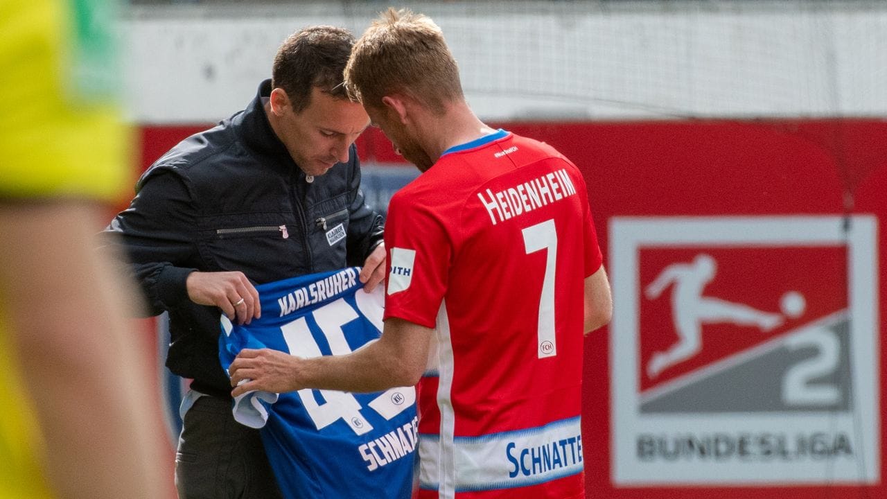 Selbst von KSC-Coach Christian Eichner erhielt Heidenheim-Legende Marc Schnatterer (r) zum Abschied ein Geschenk.