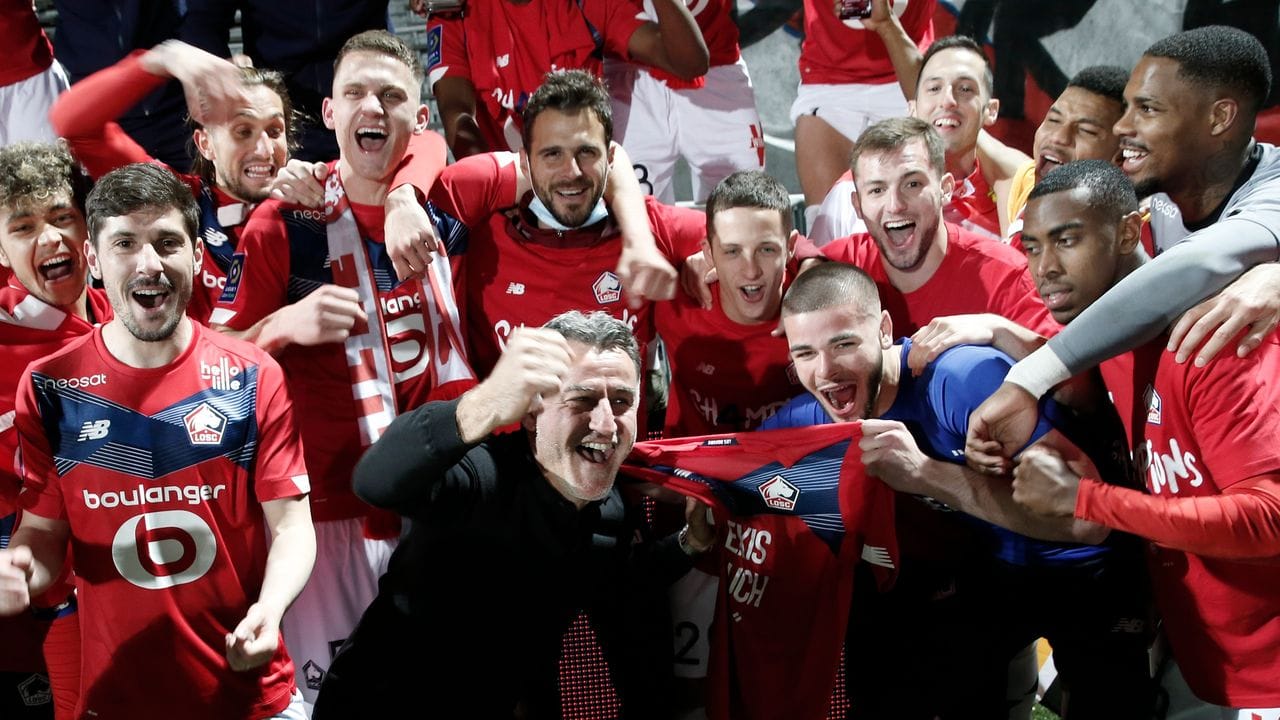Lilles Cheftrainer Christophe Galtier (M) feiert mit seinen Spielern den Titel.