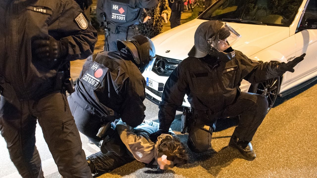 Polizisten nehmen am Zugang zum Schanzenviertel einen jungen Mann in Gewahrsam.