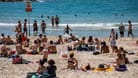 Menschen verbringen den Tag in der Sonne am Strand von Tel Aviv.