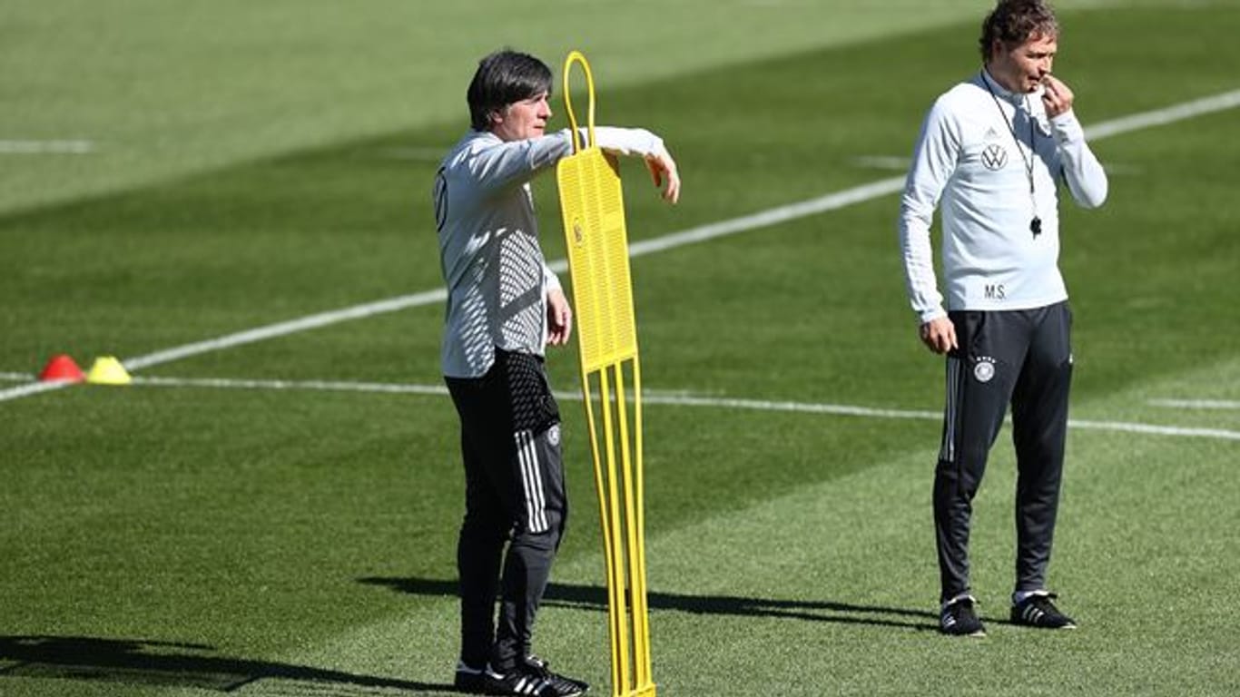Bundestrainer Joachim Löw (l) und Assistenztrainer Marcus Sorg stehen auf dem Platz beim Training.