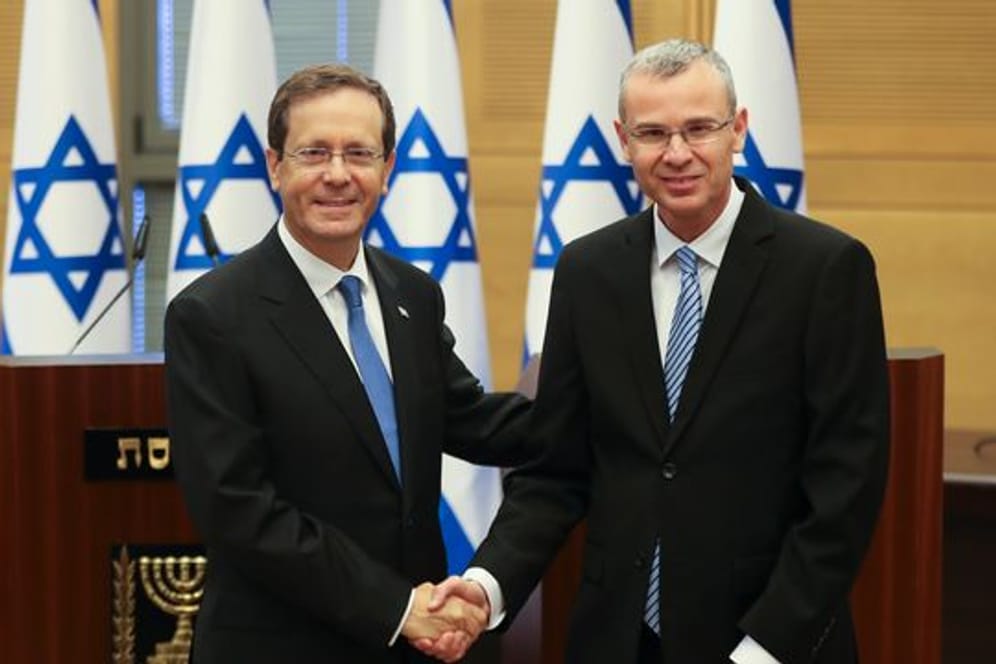 Izchak Herzog (l) gibt Knesset-Präsident Jariv Levin vor einer Sondersitzung die Hand.