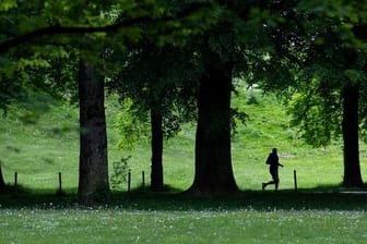 Ein Jogger ist im Englischen Garten in München unterwegs.