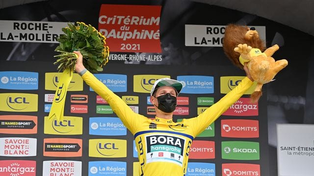 Lukas Postlberger trägt auf dem Podium das Gelbe Trikot des Gesamtführenden.