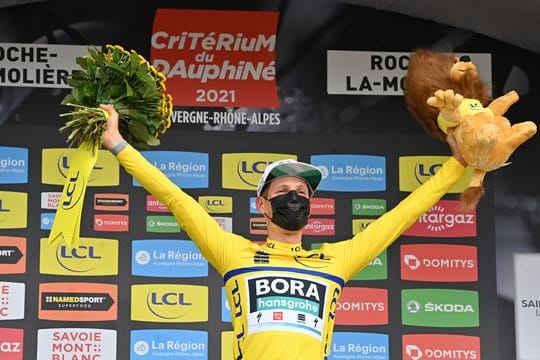 Lukas Postlberger trägt auf dem Podium das Gelbe Trikot des Gesamtführenden.