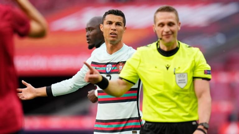 Portugals Cristiano Ronaldo (l) beschwert sich beim Schiedsrichter während des Spiels gegen Spanien.