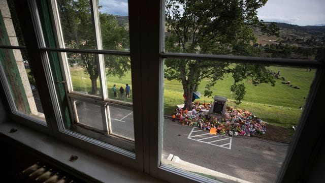 Vor der ehemaligen Kamloops Indian Residential School wurde ein behelfsmäßiges Denkmal eingerichtet. Vor der ehemaligen Kamloops Indian Residential School wurde ein behelfsmäßiges Denkmal eingerichtet.
