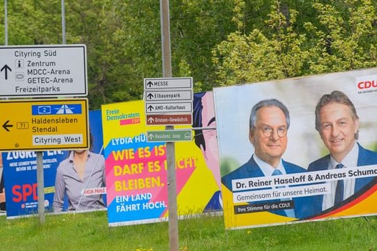 Reiner Haseloff (auf dem Plakat links) ist mit 67 im Rentenalter.