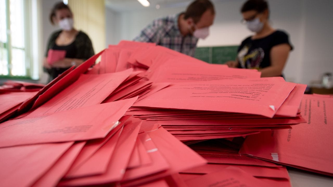 Wahlhelfer und Wahlhelferinnen öffnen in Magdeburg die Umschläge der Briefwahl.