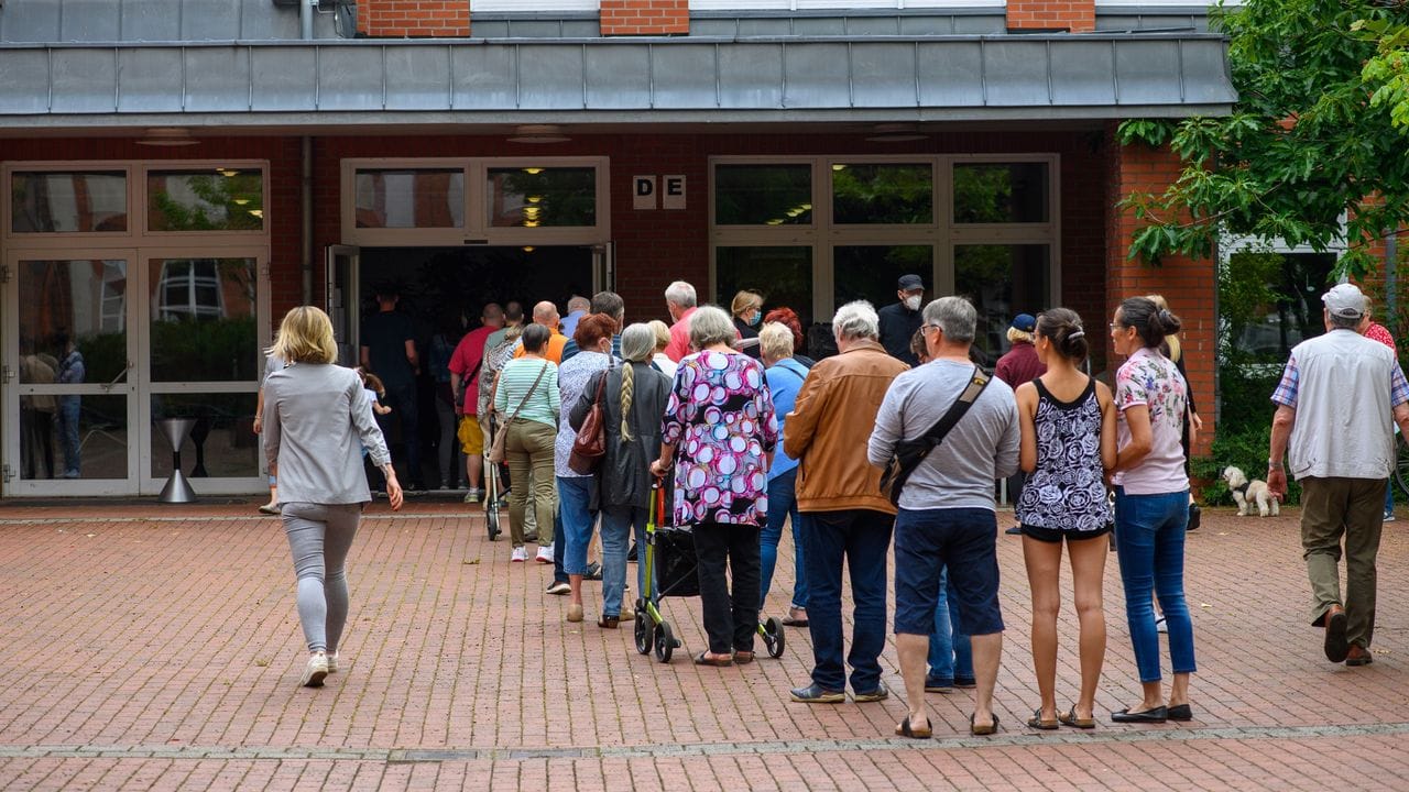 Menschen stehen vor einem Magdeburger Wahllokal Schlange.