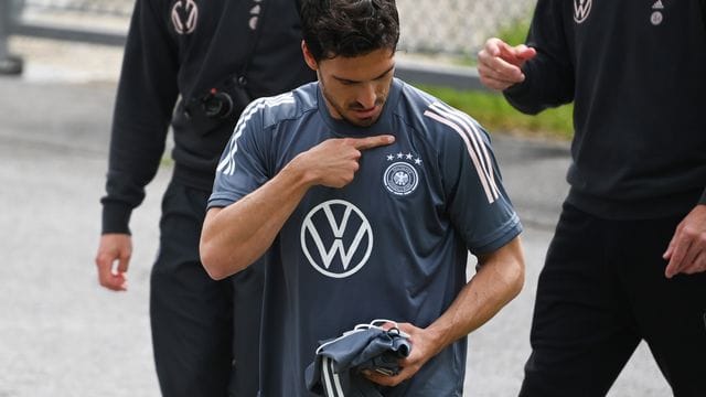 Mats Hummels schaut auf das DFB Logo auf seinem T-Shirt.