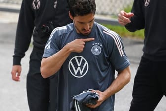 Mats Hummels schaut auf das DFB Logo auf seinem T-Shirt.