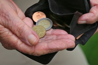 Eine Rentnerin hält einen Geldbeutel mit verschiedenen Euromünzen (gestellte Szenen).