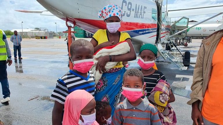 Eine Familie steht auf dem Rollfeld des Flughafens der Provinzhauptstadt Pemba, nachdem sie evakuiert wurden.