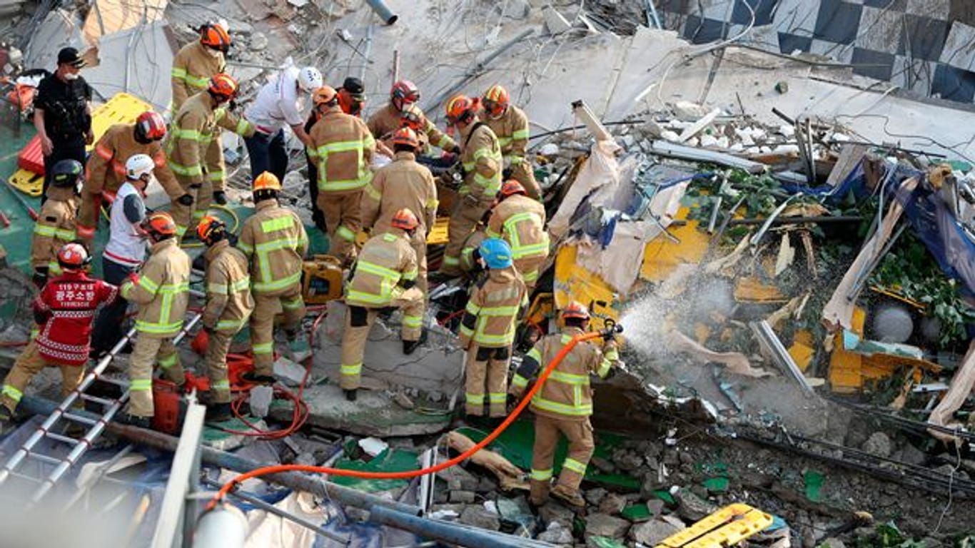 Feuerwehrleute suchen nach Überlebenden in dem eingestürzten Gebäude in Südkorea.
