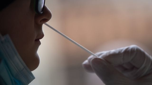 An einer Frau wird ein Corona-Schnelltest vorgenommen.