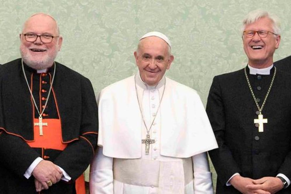 Papst Franziskus (M) lehnte den Rücktritt von Kardinal Marx (l) überraschend ab.