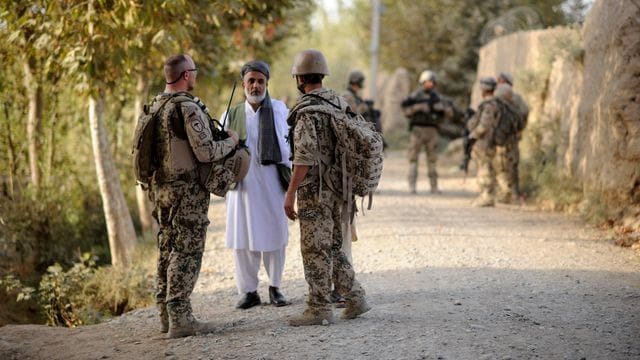 Ein Bundeswehrsoldat (l) und ein Dolmetscher (r) sprechen nahe Kundus im Distrikt von Char Darreh mit einem Mann. Ein Bundeswehrsoldat (l) und ein Dolmetscher (r) sprechen nahe Kundus im Distrikt von Char Darreh mit einem Mann.