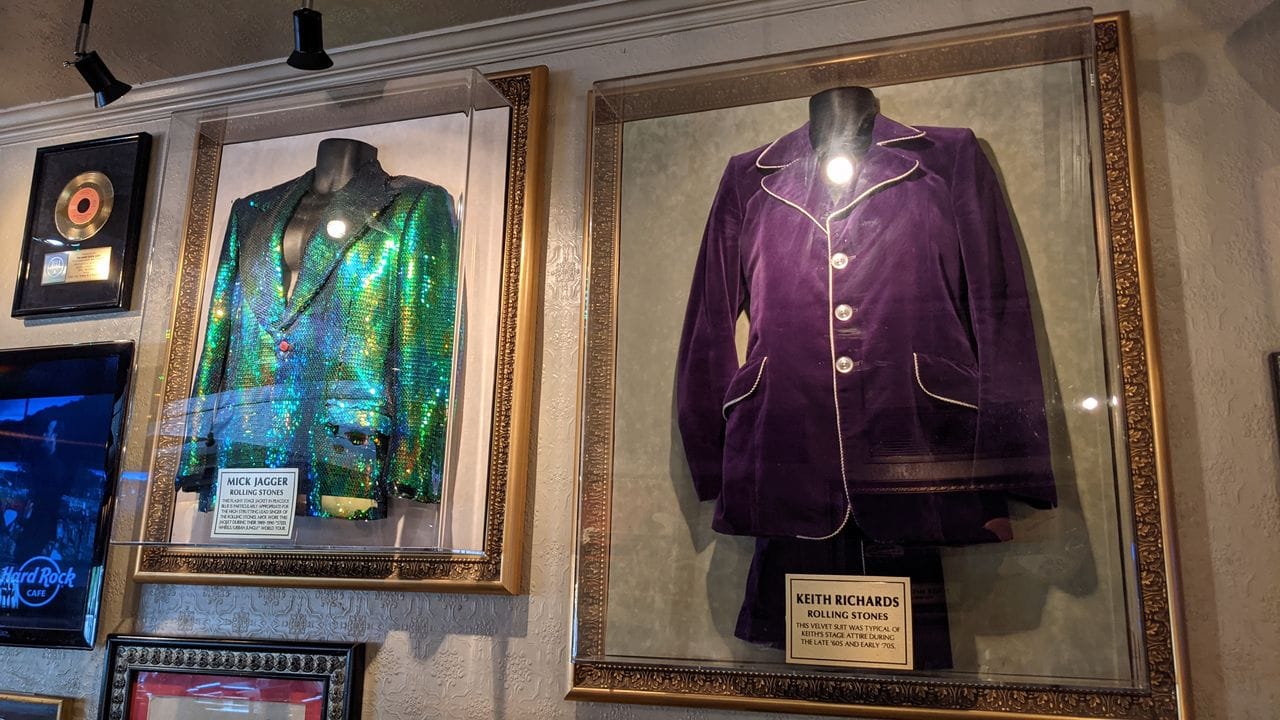 Ein Samtanzug von Rolling-Stones-Gitarrist Keith Richards, daneben Mick Jaggers grüne Jacke. Ein Samtanzug von Rolling-Stones-Gitarrist Keith Richards, daneben Mick Jaggers grüne Jacke.