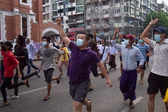 Anti-Putsch-Demonstranten zeigen das Drei-Finger-Zeichen des Widerstandes während eines Flashmobs in Yangon.