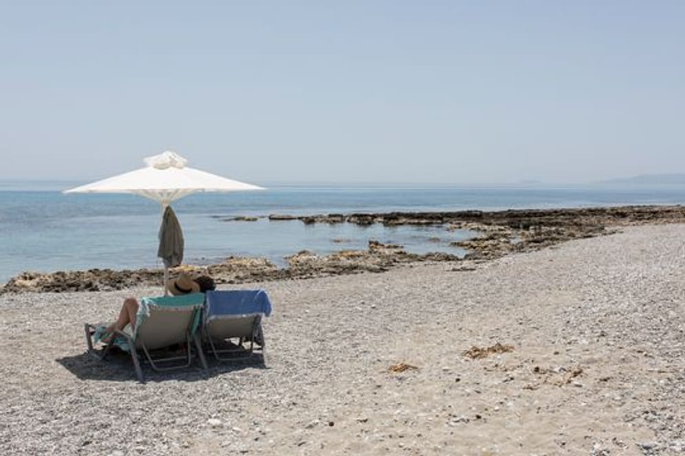 Touristen genießen den Ritsa-Strand in Kardamyli, einer Stadt am Meer fünfunddreißig Kilometer südöstlich von Kalamata, Peloponnes.