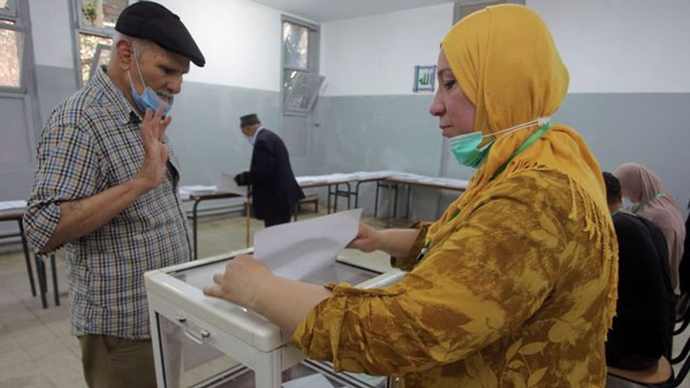 Ein Mann gibt in einem Wahllokal in Algier seine Stimme ab.
