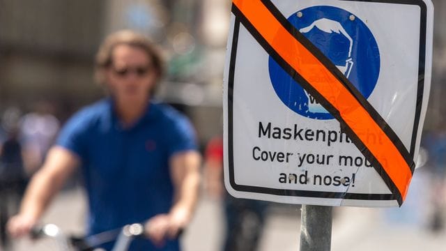 Ein mit orangen Klebeband durchgestrichenes Schild steht in der Münchner Innenstadt am Straßenrand. Ein mit orangen Klebeband durchgestrichenes Schild steht in der Münchner Innenstadt am Straßenrand.