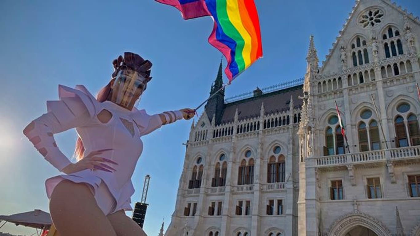 Eine Drag Queen schwenkt eine Regenbogenfahne auf einer LGBT-Rechte-Demonstration vor dem ungarischen Parlament.