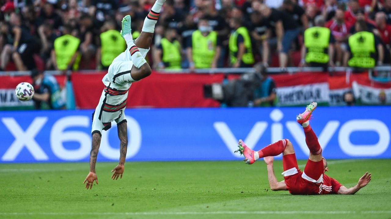 Nach einem Zweikampf mit dem Ungarn Tamas Cseri fliegt der Portugiese Nelson Semedo (l) durch die Luft. Nach einem Zweikampf mit dem Ungarn Tamas Cseri fliegt der Portugiese Nelson Semedo (l) durch die Luft.