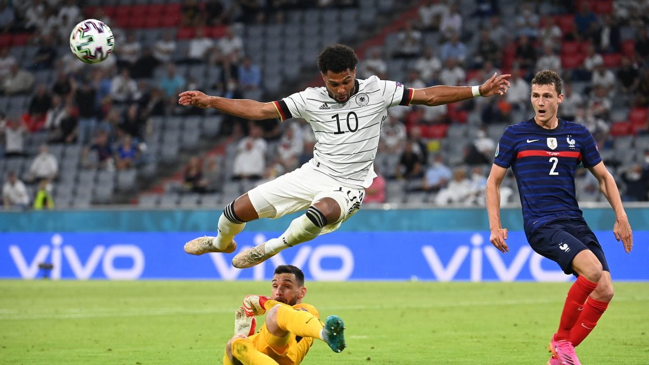 DFB-Spieler Serge Gnabry in Aktion vor dem Tor von Frankreichs Torhüter Hugo Lloris (unten).