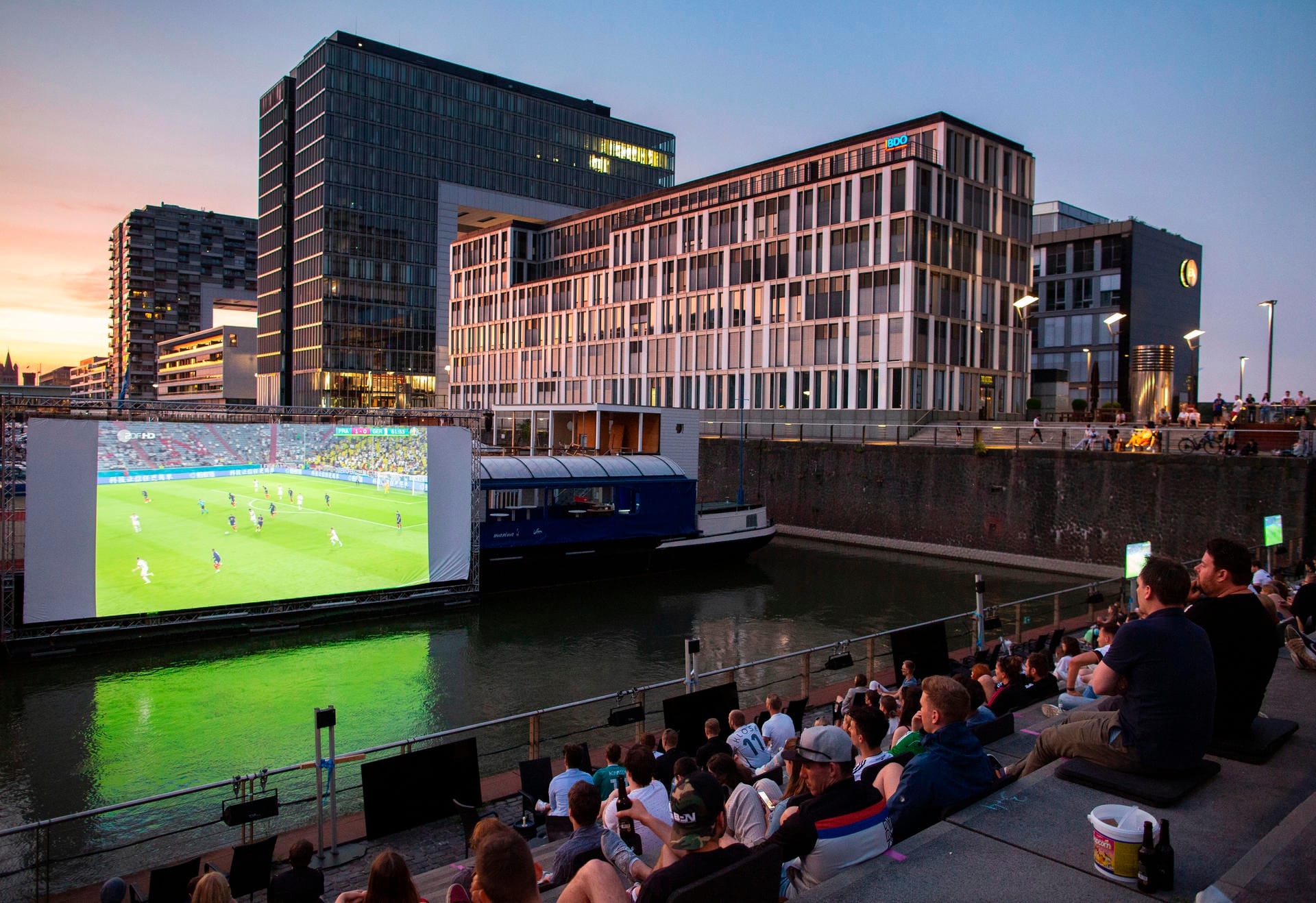 Public Viewing in der Kölner Südstadt: Auf einem riesigen Bildschirm verfolgen Fußballfans die EM-Vorrunde.