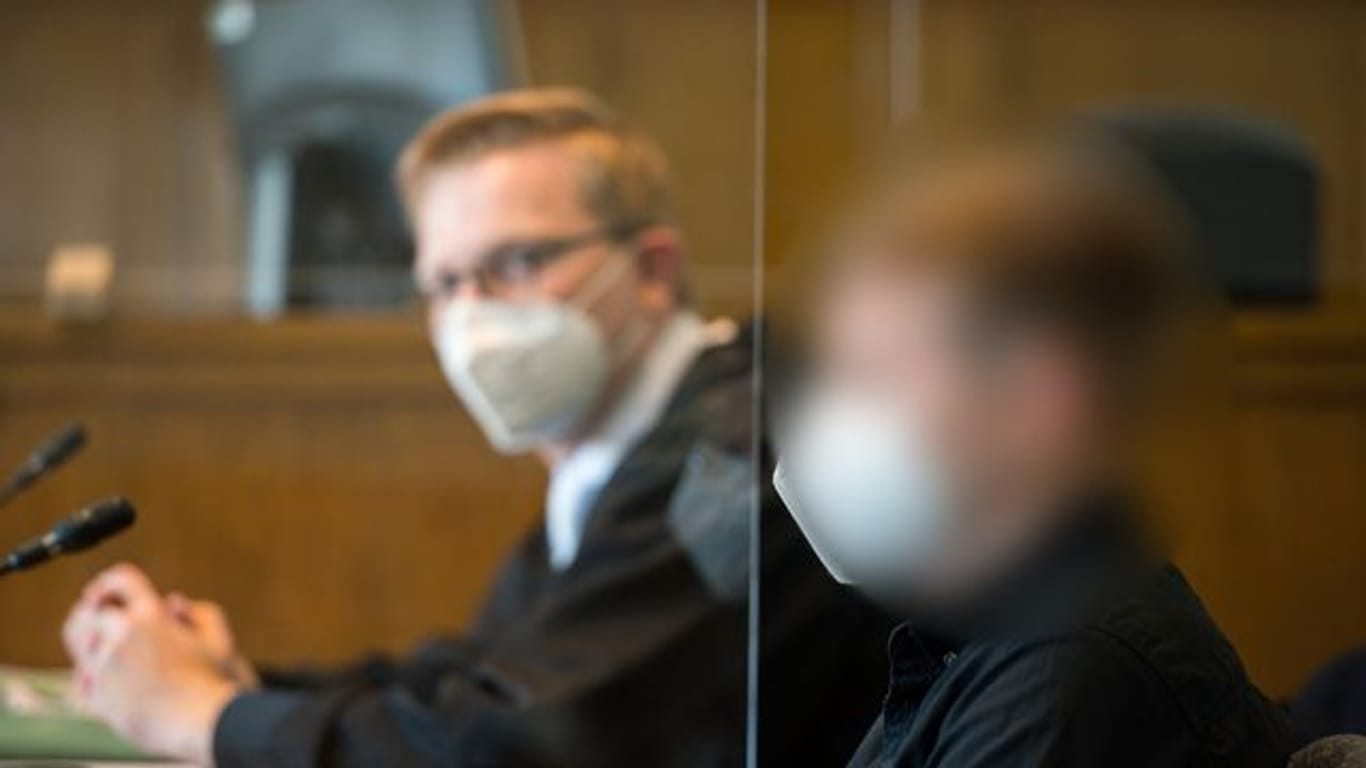 Der Angeklagte und sein Anwalt (l) sitzen im Gerichtssaal des Landgerichts Saarbrücken.