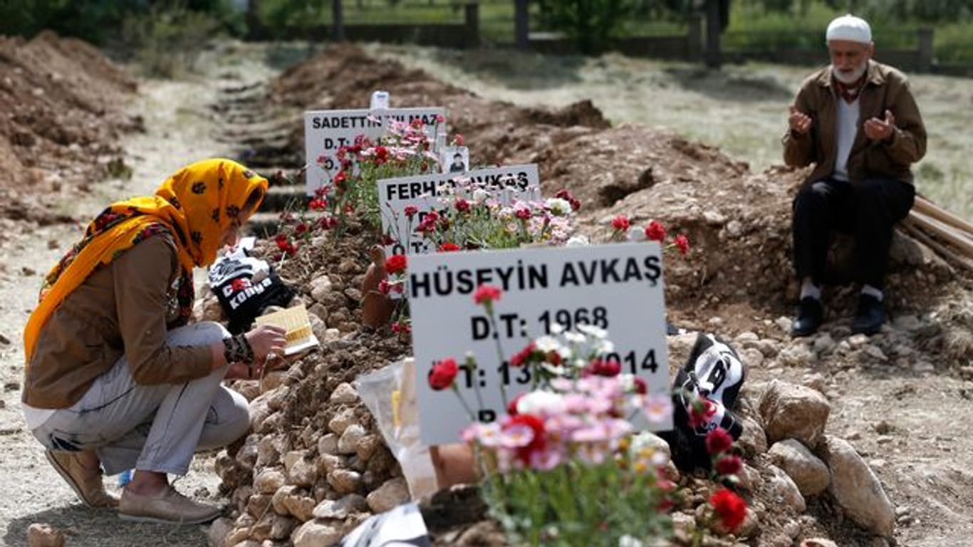 Trauernde beten an den Gräbern der bei einer Explosion in der Kohlegrube im türkischen Soma getöteten Bergleute.