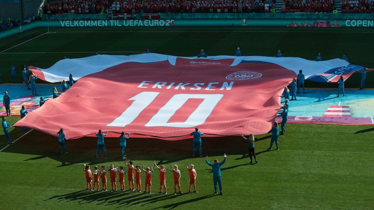 Ein riesiges Trikot zu Ehren des dänischen Spielers Eriksen wird vor dem Spiel auf das Spielfeld gebracht.