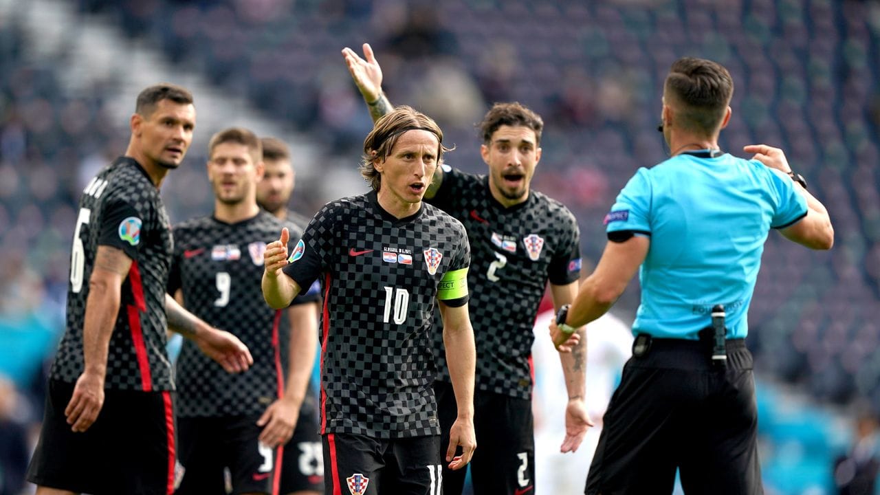 Luka Modric (M) und seine kroatischen Mitspieler reden auf Schiedsrichter Carlos del Cerro Grande (r) ein. Luka Modric (M) und seine kroatischen Mitspieler reden auf Schiedsrichter Carlos del Cerro Grande (r) ein.