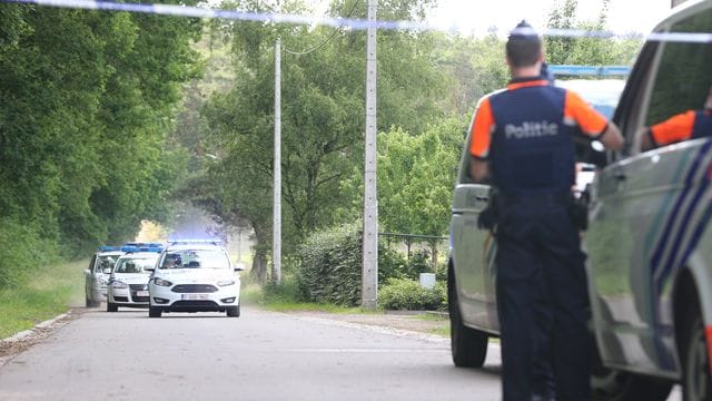 Polizeifahrzeuge fahren hinter einem abgesperrten Bereich in der Nähe des Fundorts der Leiche des gesuchten Conings im Waldgebiet Dilserbos.