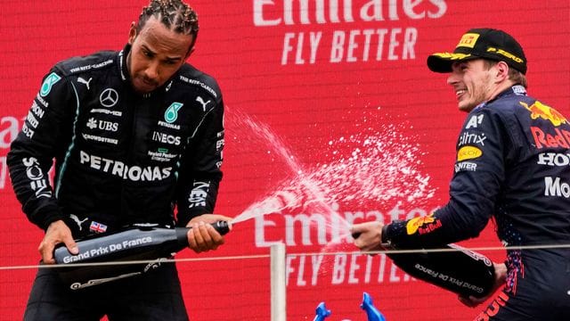 Sieger Max Verstappen (r) und der Zweitplatzierte Lewis Hamilton lassen auf dem Podium den Champagner spritzen.