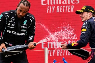 Sieger Max Verstappen (r) und der Zweitplatzierte Lewis Hamilton lassen auf dem Podium den Champagner spritzen.