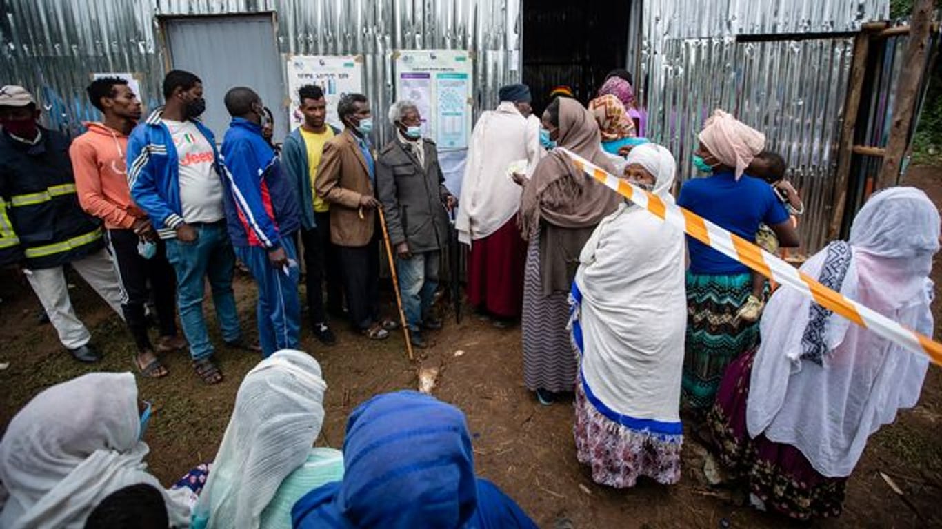 Menschen stehen vor einem Wahllokal in Addis Abeba Schlange.